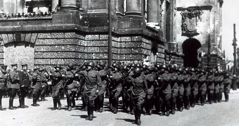 Парад в Берлине 4 мая 1945 года. Колонна 372-й Краснознамённой Новгородской стрелковой дивизии проходит у стен поверженного Рейхстага