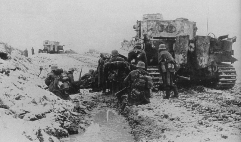 Немцы укрываются за танком во время боев за город