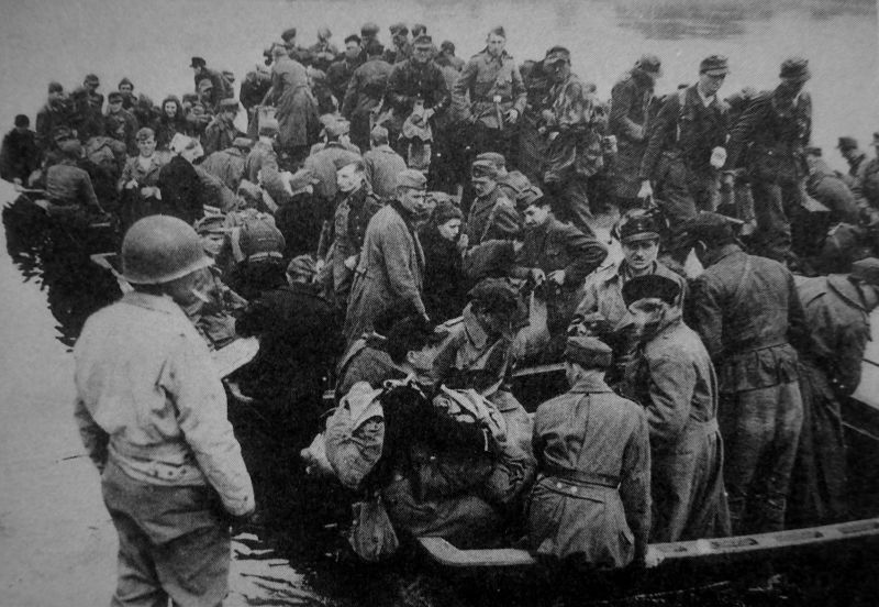 Немецкие солдаты и офицеры, в том числе женщины, призванные на военную службу, пересекают Эльбу, чтобы сдаться в плен американцам