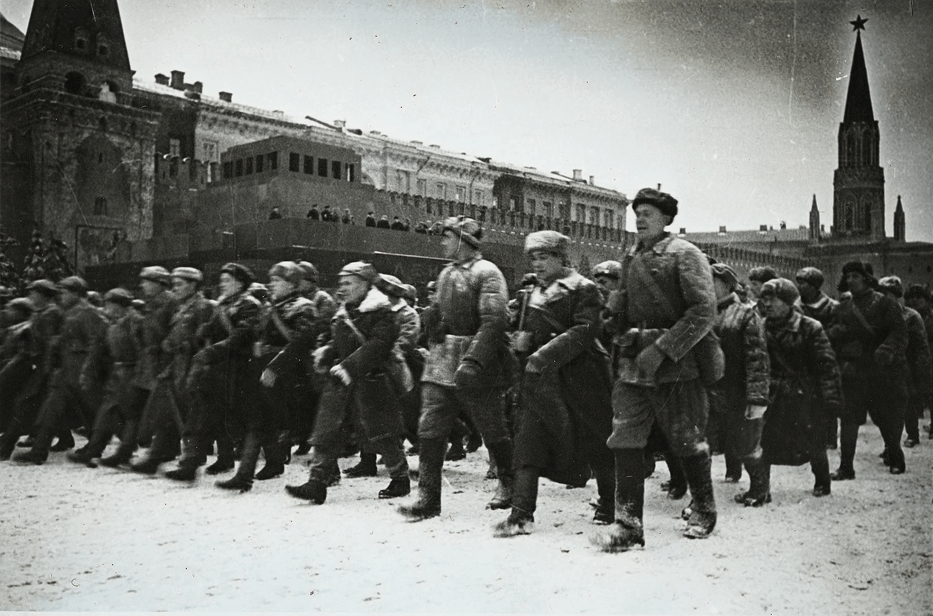 Участники Парада идут мимо трибуны Мавзолея.