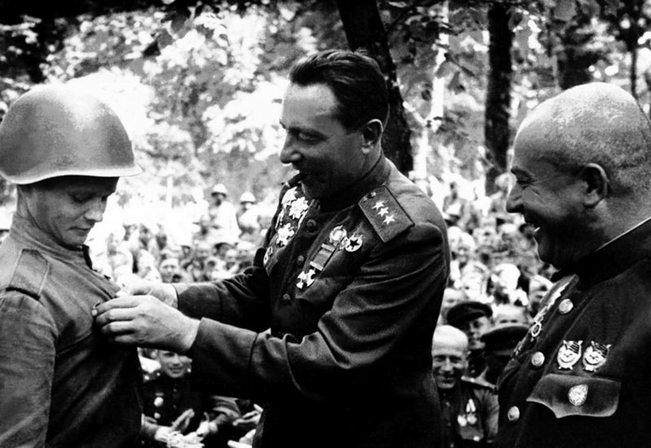 Командующий 1-й гвардейской танковой армией генерал-полковник Михаил Ефимович Катуков (1900—1976) прикрепляет к груди бойца гвардейский значок
