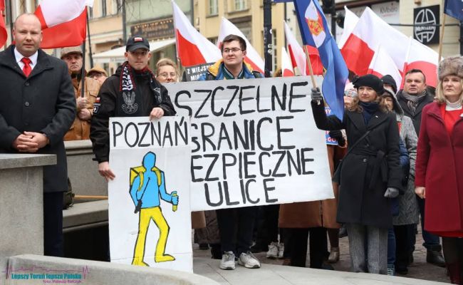 Демонстрация против мигрантов в польском Торуни. Беженец с Украины изображён с ножом.