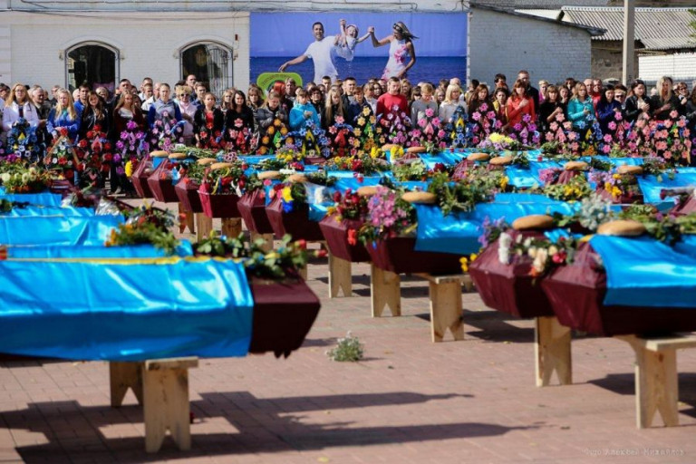 Пронзительная иллюстрация происходящего на Украине – на заднем плане изображено семейное счастье, которое было или могло бы быть, впереди – гробы…