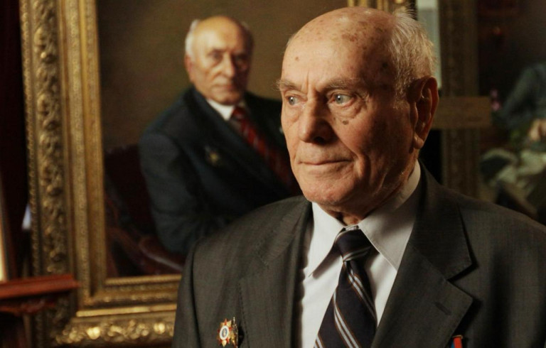 Заглавное фото. Знаменитый разведчик Алексей Ботян на фоне своего портрета 